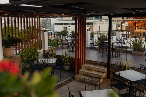 an outdoor patio with tables and chairs and tables and chairs at Hotel Boutique ADAZ in Santa Marta