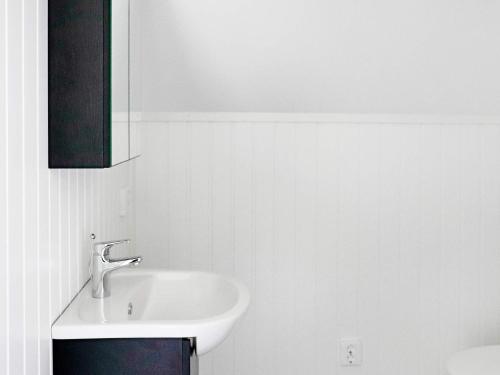 a white bathroom with a sink and a mirror at Holiday home STRÅVALLA II in Stråvalla