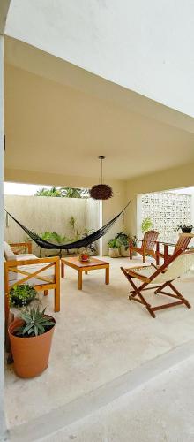 a patio with a hammock and tables and chairs at Casa Arrayan Telchac in Telchac Puerto