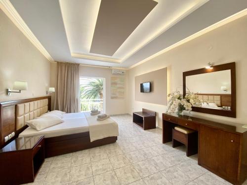 a hotel room with a bed and a mirror at Hotel Sotiris Superior Apartments in Myrina