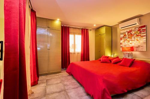 a bedroom with a red bed with red curtains at La Villa ANSALY in Sali Nianiaral