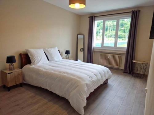a bedroom with a large white bed and a window at Superbe appartement 2 pièces - Aix-les-Bains Riviera des Alpes - Parking gratuit in Aix-les-Bains