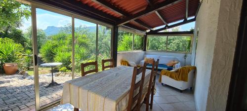 une véranda avec une table et des chaises dans l'établissement La Gaude Appart jardin 6 personnes, à La Gaude