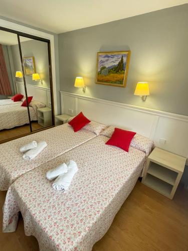 a hotel room with two beds and a mirror at RESIDENCIAL MICHELANGELO in Salou