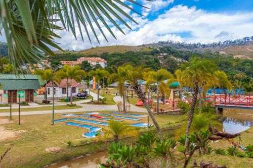 a park with a bunch of slides and palm trees at Castelo de Itaipava - Hotel, Eventos e Gastronomia in Itaipava