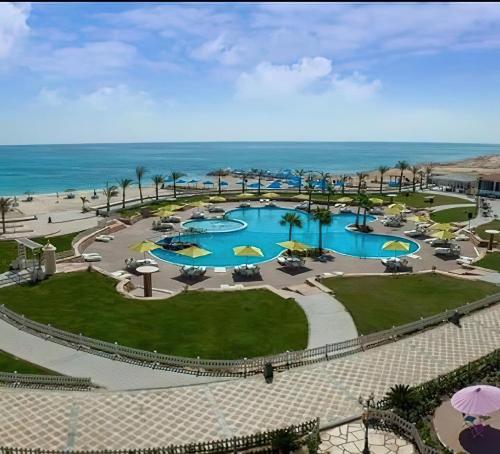 una vista aérea de un complejo con 2 piscinas y el océano en Lazorde Bay Apartment en El Alamein