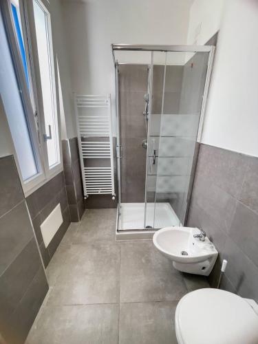 a bathroom with a shower and a toilet and a sink at Tea House Alghero in Alghero