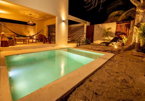 a swimming pool in front of a house at night at Casa Arrayan Telchac in Telchac Puerto