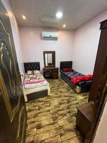 Zimmer mit 2 Betten und einem Spiegel in der Unterkunft مزرعة السمو in Baljurashi