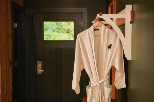 a robe hanging on a rack in front of a door at Little Cat Lodge in Hillsdale