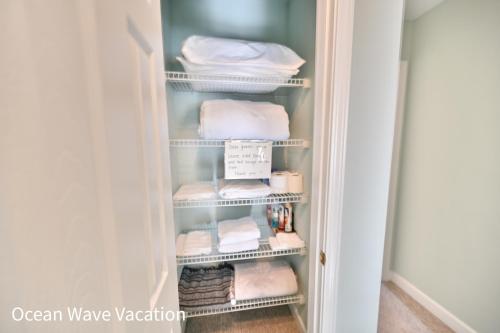 a closet with clean towels on shelves at Lovely Townhouse One Block to the Beach in Myrtle Beach