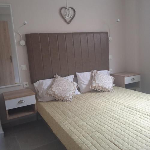 1 dormitorio con 1 cama grande con almohadas blancas en Porto Athos 0, en Nea Roda