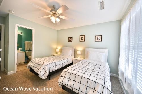 a bedroom with two beds and a ceiling fan at Lovely Townhouse One Block to the Beach in Myrtle Beach