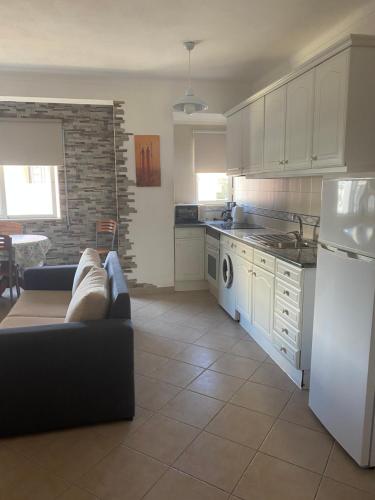 uma cozinha com um sofá e um frigorífico branco em Castelos da Rocha em Portimão