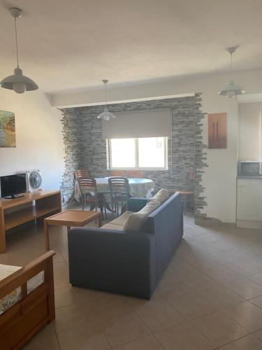 ein Wohnzimmer mit einem Sofa und einem Tisch in der Unterkunft Castelos da Rocha in Portimão