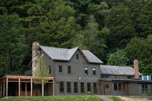 une grande maison avec un toit en gambrel dans l'établissement Little Cat Lodge, à Hillsdale