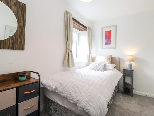 1 dormitorio con cama, espejo y ventana en The Coach House en Carnforth