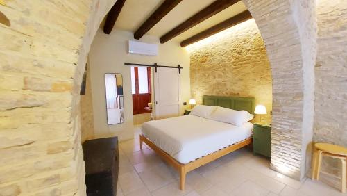 um quarto com uma cama branca numa parede de pedra em CASA OCRA em Vasto