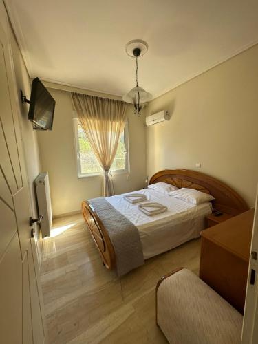 a bedroom with a large bed and a window at Villa thymari in Sounio