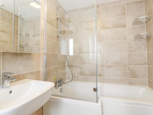 a bathroom with a shower and a sink and a tub at Corner Cottage in Carnforth