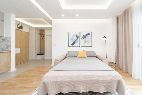 a white bedroom with a large bed in it at Salus Hill Condo with private Garage in Budva