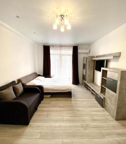 a living room with a couch and a bed at Top Apartment in Suvorovo