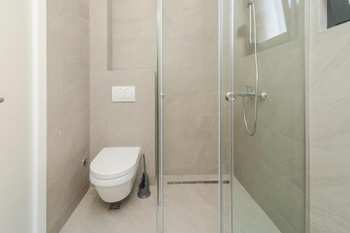 a bathroom with a toilet and a glass shower at Salus Hill Condo with private Garage in Budva