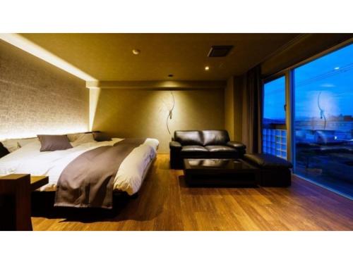 a bedroom with a bed and a chair and a window at Oita Onsen Business Resort Kyuan - Vacation STAY 50156v in Oita