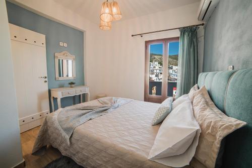 una camera da letto con un letto con pareti blu e una finestra di koronos village apartments a Kóronos