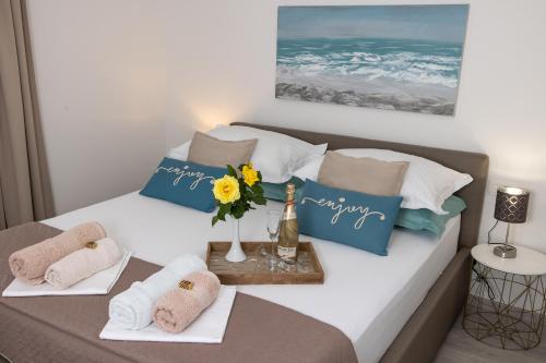 ein Bett mit Handtüchern und eine Vase Blumen darauf in der Unterkunft Rooms & Apartments Villa Anka in Tučepi
