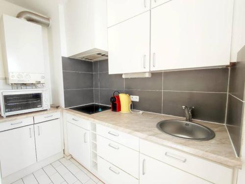 cocina con fregadero y microondas en Magnifique Vue Mer avec une chambre - Nouria 55 -, en Canet-en-Roussillon