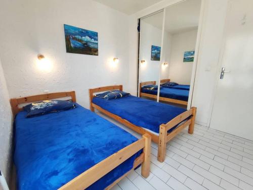 2 camas en una habitación con espejo en Magnifique Vue Mer avec une chambre - Nouria 55 -, en Canet-en-Roussillon