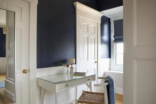 a hallway with a desk and a door with a window at The Christopher, The Edgartown Collection in Edgartown