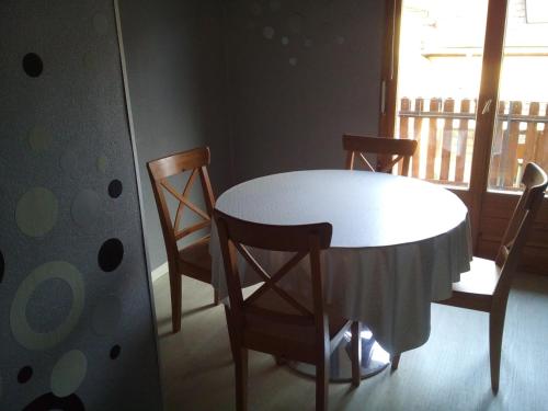 Una mesa y sillas en una habitación con ventana. en Gîte du vigneron, en Mittelwihr