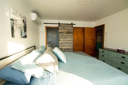 a bedroom with a bed with blue and white pillows at La Maison Mavillette The Mavillette house 2BD in Mavillette