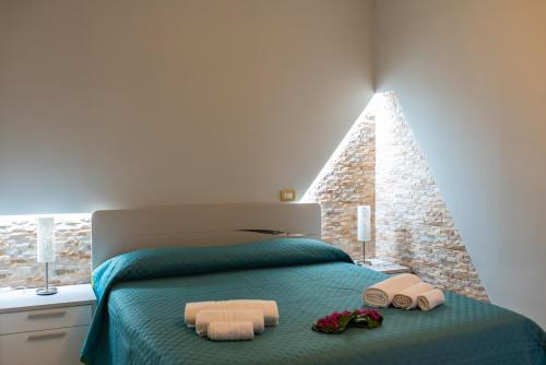 una camera da letto con un letto e due asciugamani di B&B al Vico Pepe a Castelmezzano