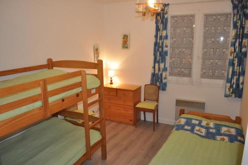 une chambre avec deux lits superposés et un bureau dans l'établissement Jolie maison familiale oleronaise, à Saint-Georges-dʼOléron