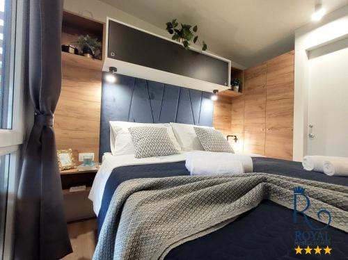 een slaapkamer met een groot bed en een blauwe deken bij Royal R mobile homes, kamp Soline, Biograd in Biograd na Moru