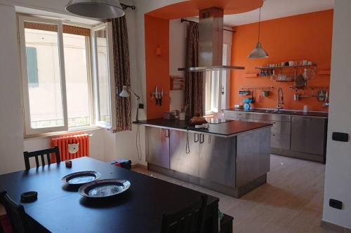 uma cozinha com uma mesa e uma cozinha com paredes cor de laranja em Appartamento La Valle em Passignano sul Trasimeno
