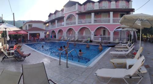a pool in front of a building with people in it at Giannis Studios in Alykes
