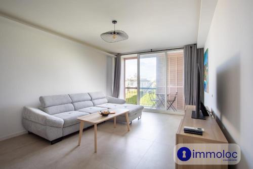 una sala de estar con un sofá y una mesa en Air-conditioned studio 5 minutes from the beach and shops, en Cros-de-Cagnes