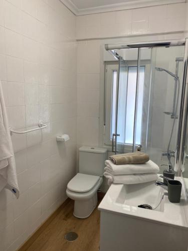 a white bathroom with a toilet and a sink at Pleno centro, cerca de todo con wifi gratis y ascensor in Santander