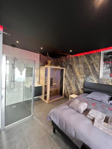 une chambre avec un grand lit et une douche dans l'établissement spa de la quarterelle LOVE ROOM 88 VOSGES, à Remiremont