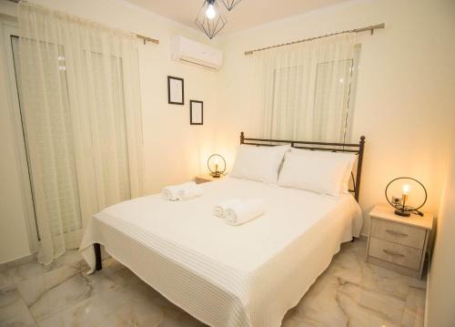 a bedroom with a large white bed with towels on it at Villa Amare in Porto Heli