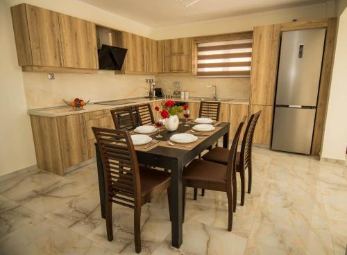 eine Küche mit einem Tisch mit Stühlen und einem Kühlschrank in der Unterkunft Villa Amare in Porto Heli
