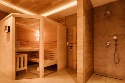 sauna con paredes de madera y ducha en Villa Greystone en Nová Lesná