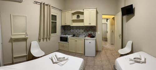 uma cozinha com duas camas brancas num quarto em Maro's Apartments em Argostoli