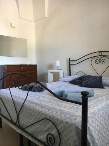 a bedroom with a bed and a dresser at La Racioppola in Ostuni