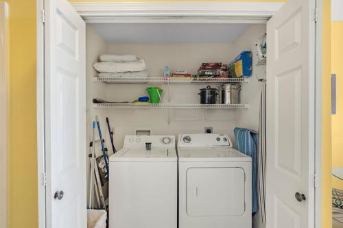 a small laundry room with a washer and dryer at The Dunes 502 by Vacation Homes Collection in Gulf Shores
