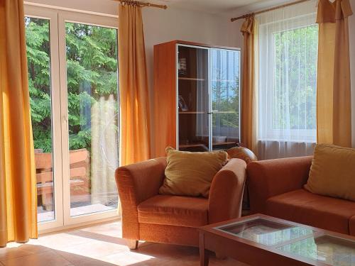 a living room with a couch and a large window at Dom Kapitana in Mikołajki
